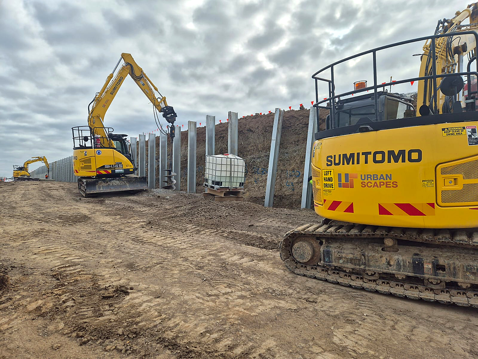Urbanscapes excavators installing steel posts for a retaining wall