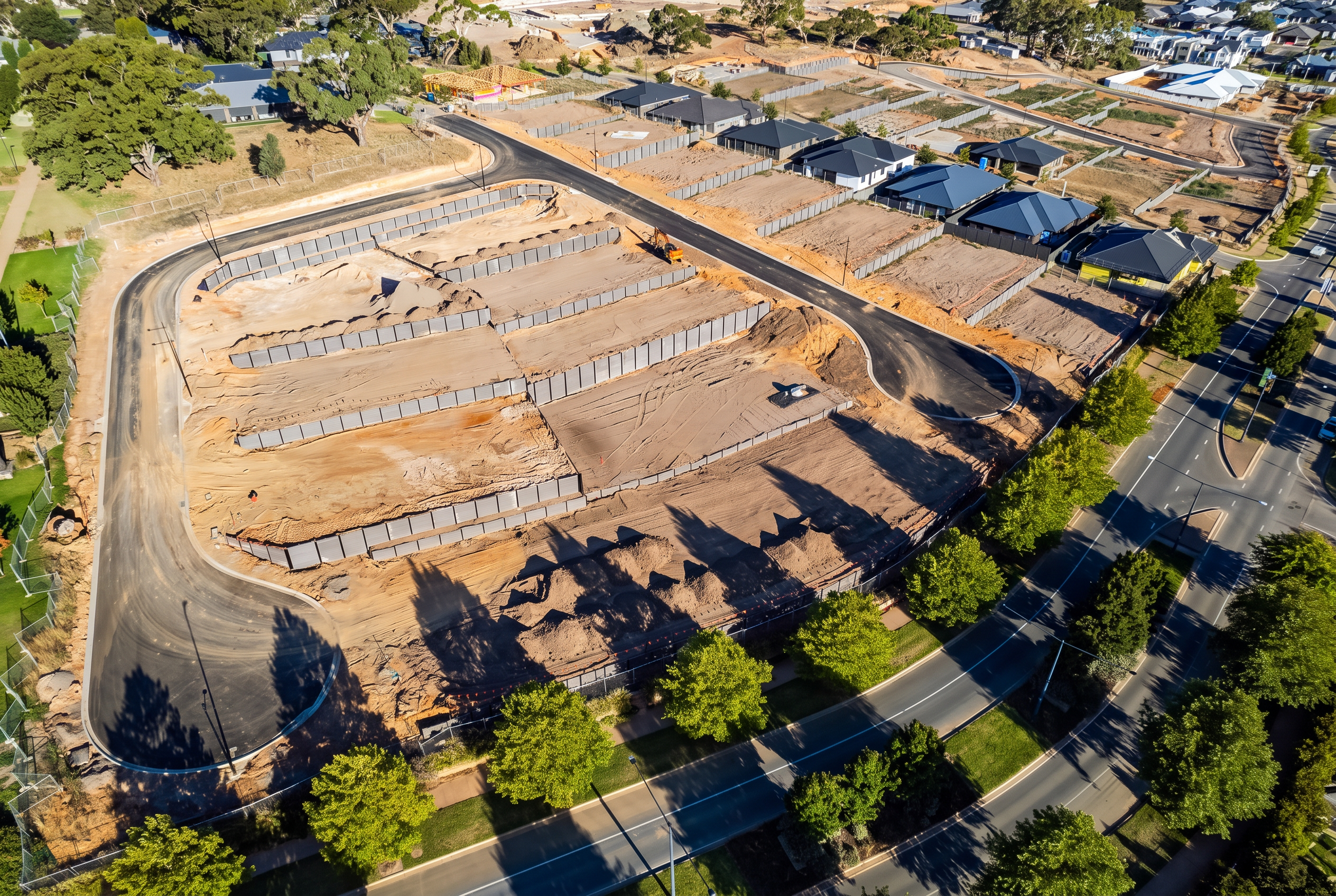 Aerial view of terraced concrete panel retaining walls in a residential subdivision